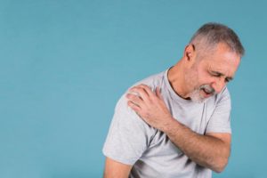 stressed senior man with shoulder pain blue